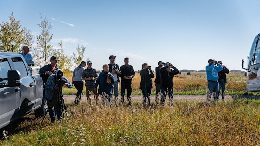 Catherine Jardine, Birds Canada's Associate Director of Data Science and Technology, holds up a tablet displaying NatureCounts out in the field.